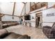 Open-concept living room with vaulted ceilings, wood beam accents, a cozy sofa, and access to the second-story loft at 360 Patience Dr, Concord, NC 28025