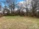 Large backyard with mature trees, offering plenty of room for outdoor activities at 4137 Poplar Tent Rd, Concord, NC 28027