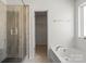 A bright bathroom featuring a glass shower, bathtub, and neutral decor at 439 Newfound Hollow Dr, Charlotte, NC 28214