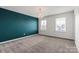 Large bedroom with plush carpeting, neutral-colored walls, and abundant natural light from two large windows at 439 Newfound Hollow Dr, Charlotte, NC 28214