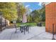 Well-maintained backyard featuring a patio, outdoor dining area, and mature trees at 4635 General Pershing Dr, Charlotte, NC 28209