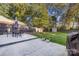 Lush backyard featuring a patio with a dining set, a shed, and mature trees at 4635 General Pershing Dr, Charlotte, NC 28209