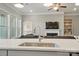 A kitchen island offers a stainless sink and view into the open concept living area at 5004 Oakmere Rd, Waxhaw, NC 28173