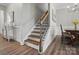 Staircase featuring wood treads and iron balusters, complemented by elegant wall paneling at 5004 Oakmere Rd, Waxhaw, NC 28173