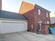 Brick house features an attached garage, an enclosed patio, and outdoor string lighting for the coming warm months at 508 Summerfield Pl, Belmont, NC 28012
