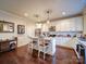 Kitchen featuring a central island with seating, white cabinets, stainless steel appliances, and hardwood floors at 508 Summerfield Pl, Belmont, NC 28012