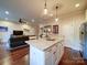 Kitchen island with seating, granite countertop, and pendant lights, blending into the living area with comfortable seating at 508 Summerfield Pl, Belmont, NC 28012