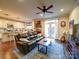 Open-concept living room with hardwood floors, a leather sofa and access to the kitchen and backyard at 508 Summerfield Pl, Belmont, NC 28012