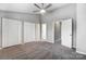 Large bedroom featuring a ceiling fan, plush carpet, and multiple closet doors at 6210 Windsor Gate Ln, Charlotte, NC 28215