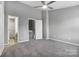 Cozy bedroom showcasing plush carpet, neutral colors, a ceiling fan, and two entryways at 6210 Windsor Gate Ln, Charlotte, NC 28215