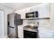 Bright kitchen equipped with stainless steel appliances, white cabinets, and ample countertop space at 6210 Windsor Gate Ln, Charlotte, NC 28215