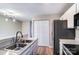 Updated kitchen featuring a stainless steel sink, appliances, and modern lighting fixture at 6210 Windsor Gate Ln, Charlotte, NC 28215