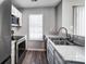 Updated kitchen showcasing stainless steel appliances, gray cabinetry, and lots of natural light at 6210 Windsor Gate Ln, Charlotte, NC 28215