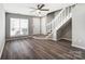 Open-concept living room with hardwood floors, natural light, and a stylish ceiling fan at 6210 Windsor Gate Ln, Charlotte, NC 28215
