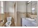 Modest bathroom showcasing a single sink vanity, tiled walls, a toilet, and a small window at 6285 Nc 16 N Hwy, Taylorsville, NC 28681