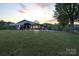 Ranch home featuring an expansive lawn, carport, and picturesque mountain views during a tranquil sunset at 6285 Nc 16 N Hwy, Taylorsville, NC 28681
