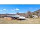 A single-story brick home features an attached carport, surrounded by the natural beauty of the landscape at 6285 Nc 16 N Hwy, Taylorsville, NC 28681