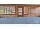 Sunroom with blue carpet, wood paneled walls, multiple windows, and an exterior door to the backyard at 6285 Nc 16 N Hwy, Taylorsville, NC 28681
