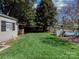 Spacious backyard with a storage shed, lush green grass, and a glimpse of a pool at 6319 Hazelton Dr, Charlotte, NC 28210