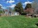 Expansive backyard features lush green lawn, storage shed, a fire pit, and mature trees at 6319 Hazelton Dr, Charlotte, NC 28210