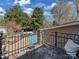 Balcony view overlooking the lush backyard with mature trees, a pristine pool, and relaxing lounge area at 6319 Hazelton Dr, Charlotte, NC 28210