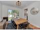 Inviting dining area with modern lighting, a wooden table, and views of the backyard for pleasant meals at 6319 Hazelton Dr, Charlotte, NC 28210