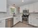 Well-lit kitchen featuring white cabinetry, stainless steel appliances, and a stylish backsplash for a modern feel at 6319 Hazelton Dr, Charlotte, NC 28210