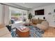 Cozy living room featuring a large window seat, stylish decor, and hardwood floors for comfortable living at 6319 Hazelton Dr, Charlotte, NC 28210