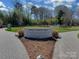 Park entrance featuring a commemorative sign and paved walkways surrounded by greenery at 6319 Hazelton Dr, Charlotte, NC 28210