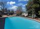 Stunning pool surrounded by landscaping, an outdoor seating area, and a cozy fire pit at 6319 Hazelton Dr, Charlotte, NC 28210