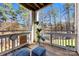 A cozy covered deck with seating overlooks a scenic wooded backyard and lawn at 921 Northeast Dr # 26, Davidson, NC 28036