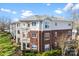 View of a three-story condo building with balconies, brick facade, and manicured landscaping at 921 Northeast Dr # 26, Davidson, NC 28036