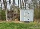 A backyard shed sits on a lawn and has a stack of logs next to it at 1004 Canopy Dr, Indian Trail, NC 28079