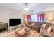 Living room featuring a brown sectional sofa, a wooden coffee table, and a large TV at 10406 Little Whiteoak Rd, Charlotte, NC 28215