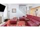 Comfortable living room showcasing a red leather sectional, staircase, fireplace, and bright natural lighting at 10406 Little Whiteoak Rd, Charlotte, NC 28215