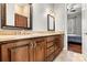 Bathroom featuring a double vanity with granite countertop, warm wood cabinets, and framed mirrors at 106 Wolf Hill Dr, Mooresville, NC 28117