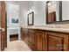 Bathroom featuring a double vanity with granite countertop, warm wood cabinets, and framed mirrors at 106 Wolf Hill Dr, Mooresville, NC 28117