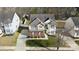 An aerial view of a two-story home with a well-maintained lawn and long driveway surrounded by mature trees at 12028 Regal Lily Ln, Huntersville, NC 28078