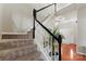 Welcoming entry featuring a staircase with black banister, hardwood floors, and a view to the front door at 12028 Regal Lily Ln, Huntersville, NC 28078