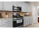 Modern kitchen with a stainless steel gas range, microwave, and neutral backsplash, perfect for cooking enthusiasts at 12028 Regal Lily Ln, Huntersville, NC 28078