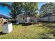 View of the spacious backyard, grass, mature trees, and rear of the house at 1216 E Cedar Ave, Gastonia, NC 28054