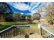 Lush backyard view from a small deck shows a beautiful backdrop of mature shade trees at 1216 E Cedar Ave, Gastonia, NC 28054