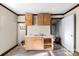 Modest kitchen features light wood cabinets, double sink, and unfinished floors for a vintage feel at 1216 E Cedar Ave, Gastonia, NC 28054