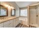 A serene bathroom with double vanity, tub, and separate glass-enclosed shower at 12332 Ridge Cove Cir, Charlotte, NC 28273