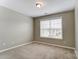 A light-filled bedroom with a large window and plush neutral carpeting at 12332 Ridge Cove Cir, Charlotte, NC 28273