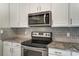 Modern kitchen featuring stainless steel appliances, granite countertops, and white cabinets at 12332 Ridge Cove Cir, Charlotte, NC 28273