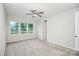 Bright bedroom featuring a ceiling fan, neutral carpet, and three large windows at 1270 Brawley School Rd # E, Mooresville, NC 28177