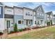 View of townhomes featuring modern architecture, white picket fences, and well-maintained landscaping at 1270 Brawley School Rd # E, Mooresville, NC 28177