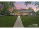 Charming home with manicured lawn and walkway at dusk at 1359 Carmen Ln, Gastonia, NC 28054