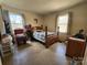 Cozy bedroom with twin windows and natural light, furnished with a four-poster bed and vintage furniture at 1377 S Aspen St, Lincolnton, NC 28092